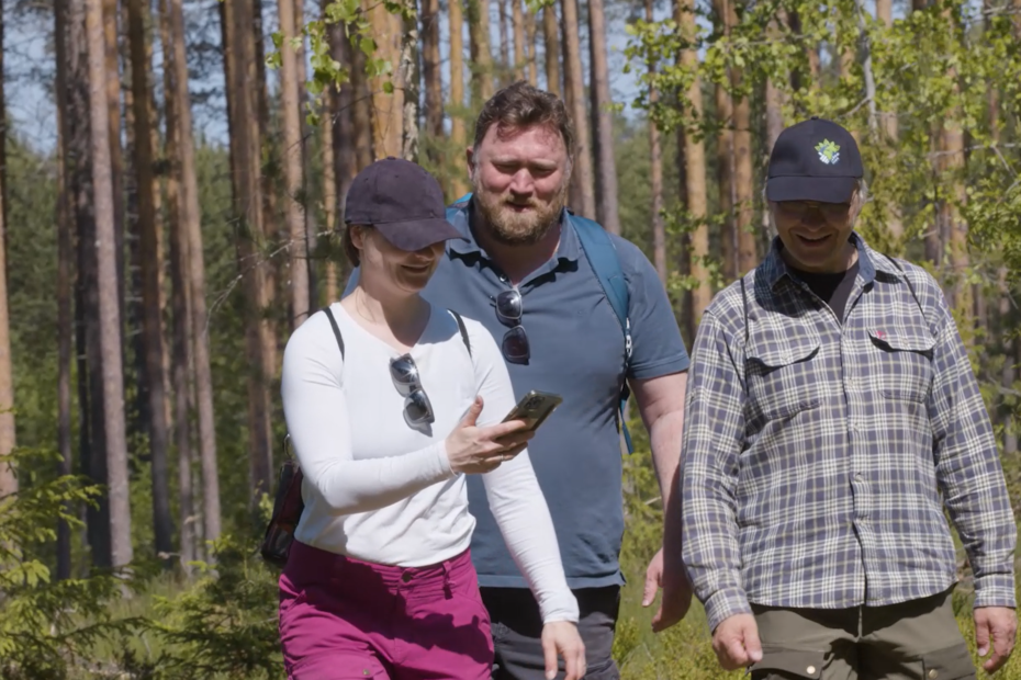 Kolme tutkijaa kävelee metsässä.